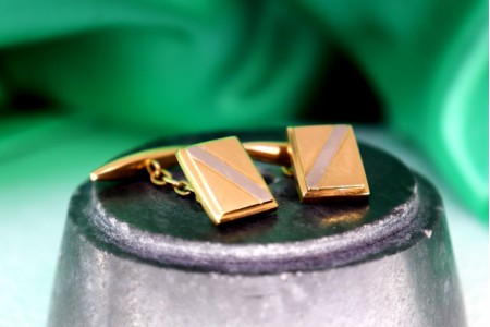 Botões de punho em ouro bicolor retangulares com banda em diagonal.